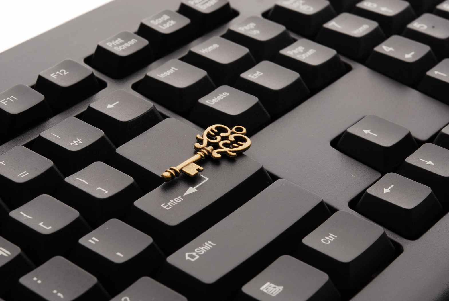 brass ornate vintage key on black computer keyboard for article on how to use keywords to boost SEO score