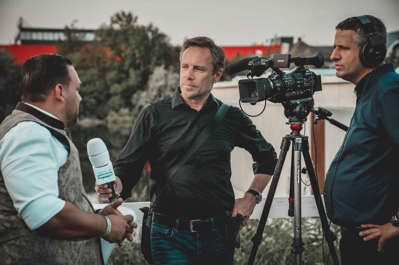 man holding microphone while talking to journalist for a blog post highlighting what corporate journalism is and how it can help businesses tell their story